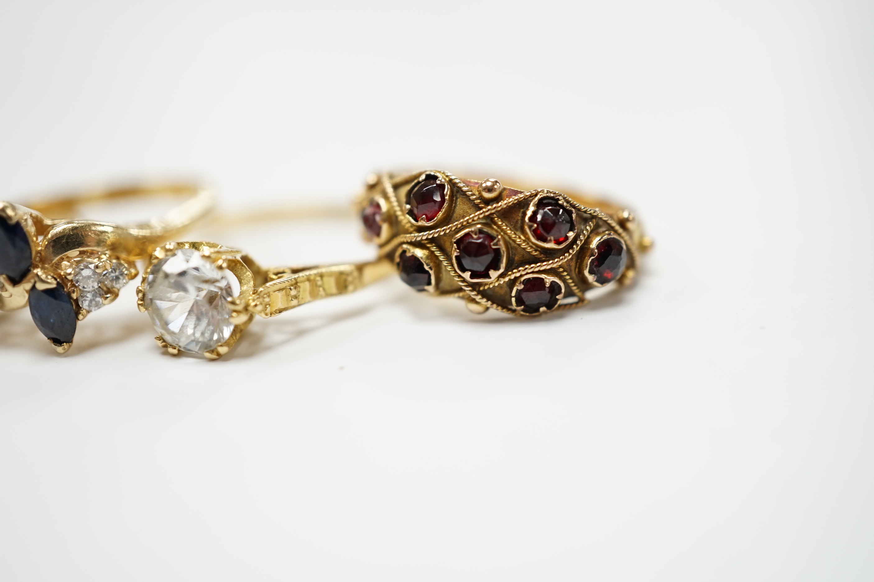 An Edwardian 15ct?, white opal, emerald and amethyst cluster set ring, in the Suffragette colours, size F, together with four other yellow metal and gem set rings including three stone illusion set diamond and a 14k sapp